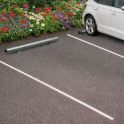Butée de parking galvanisée installée sur un stationnement d'entreprise