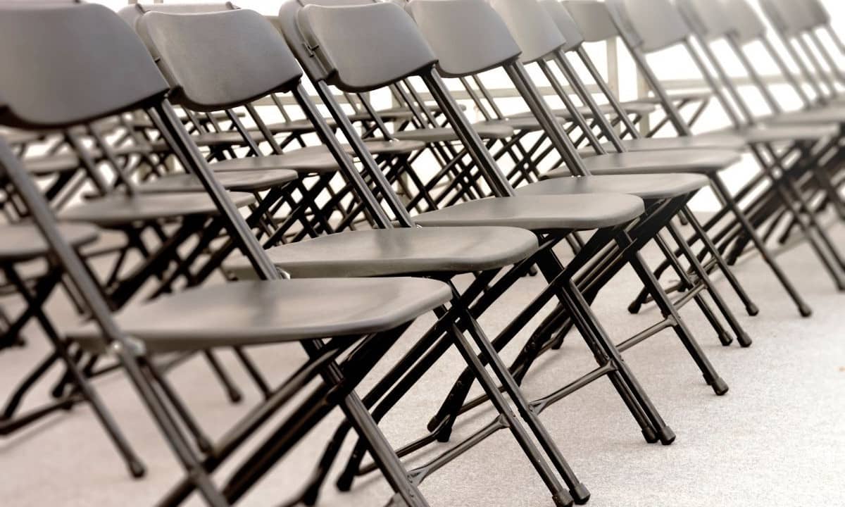 chaises pliantes noires installées en rangées en intérieur